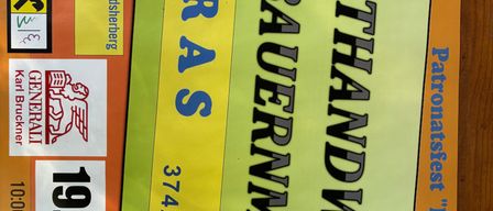 A promotional poster for the Kunsthandwerkermarkt event in Pfarrhof, Theras. The poster features a yellow and green background with black text. It includes a date of 19.8.20, a price of 100.00 EUR, and a logo.