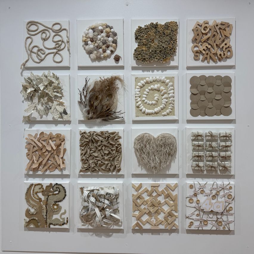 Eine Collage verschiedener Kunstwerke, die an einer weißen Wand ausgestellt sind. Jedes Stück ist einzigartig und aus Materialien wie Papier, Holz und anderen Gegenständen hergestellt. Die Sammlung umfasst komplizierte Designs und Muster.