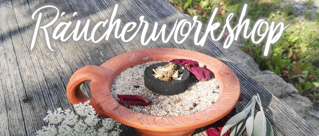 Eine Tonschale mit Kräutern und Blütenblättern steht auf einem Holztisch. Eine weiße Blume und grüne Blätter sind in der Nähe. Das Wort 'Rauchworkshop' steht über der Schale.