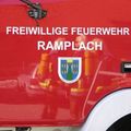 Ein roter Feuerwehrwagen mit den Worten 'Freiwillige Feuerwehr Ramplach' und einem Wappenlogo mit 'Marktgemeinde Wartmannstetten' an der Seite.
