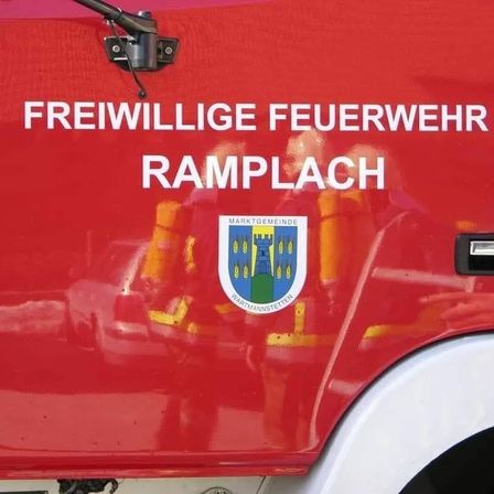 Ein roter Feuerwehrwagen mit den Worten 'Freiwillige Feuerwehr Ramplach' und einem Wappenlogo mit 'Marktgemeinde Wartmannstetten' an der Seite.