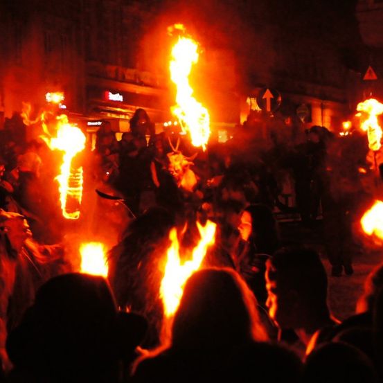 Eine große Menschenmenge versammelte sich nachts und hielt brennende Fackeln in der Hand, die den dunklen Bereich erhellten.