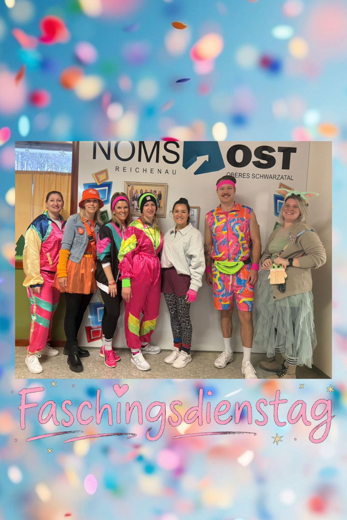Eine Gruppe von Menschen in leuchtenden, farbenfrohen Kostümen posiert für ein Foto vor einem Schild, das 'Faschingsdienstag' steht. Sie lächeln und scheinen ein Ereignis zu feiern.
