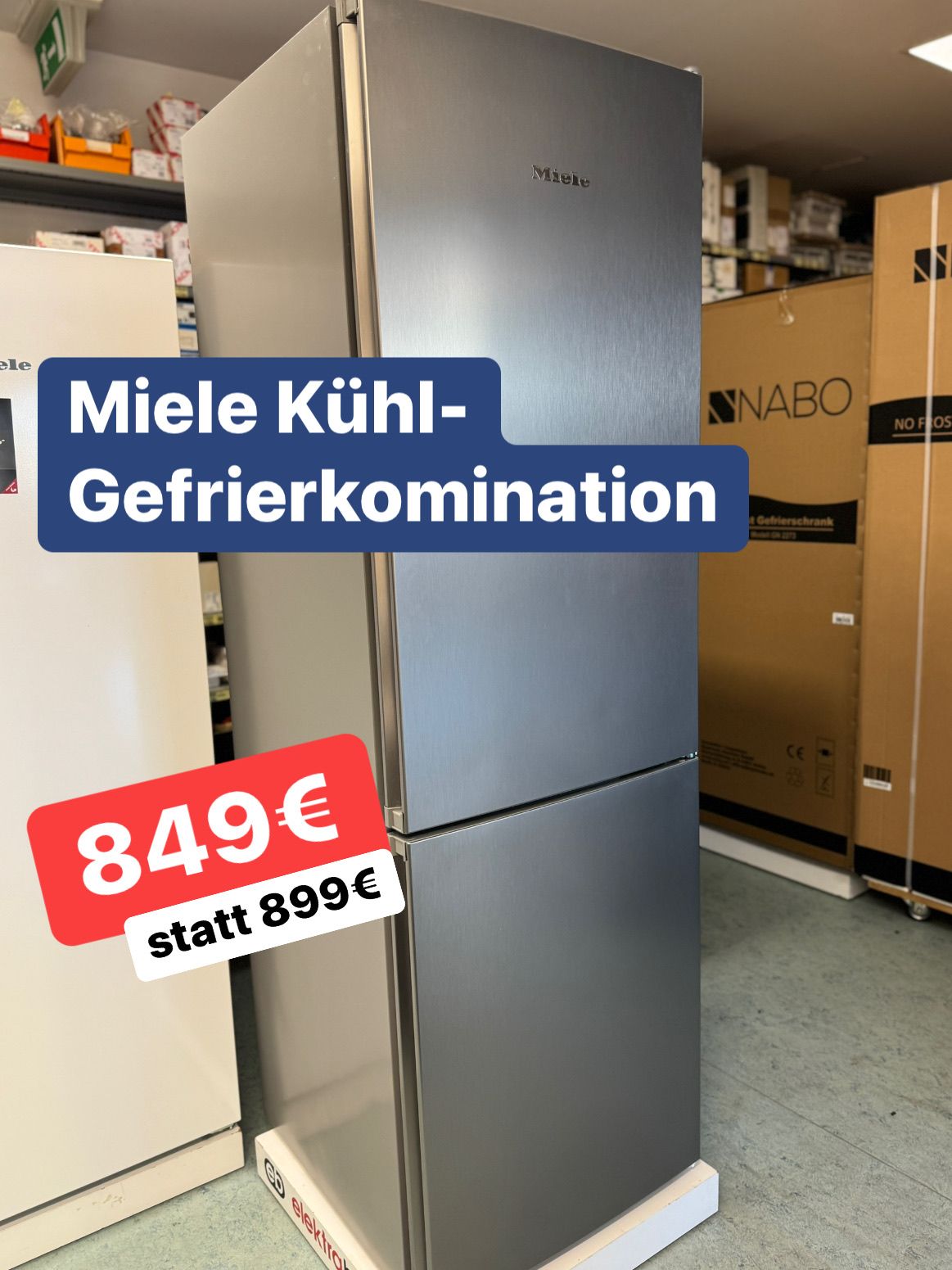 Ein silberner Miele-Kühlschrank steht in einem Lager. Ein roter Preisschild zeigt 849€ statt 899€. Im Hintergrund befinden sich Kisten.