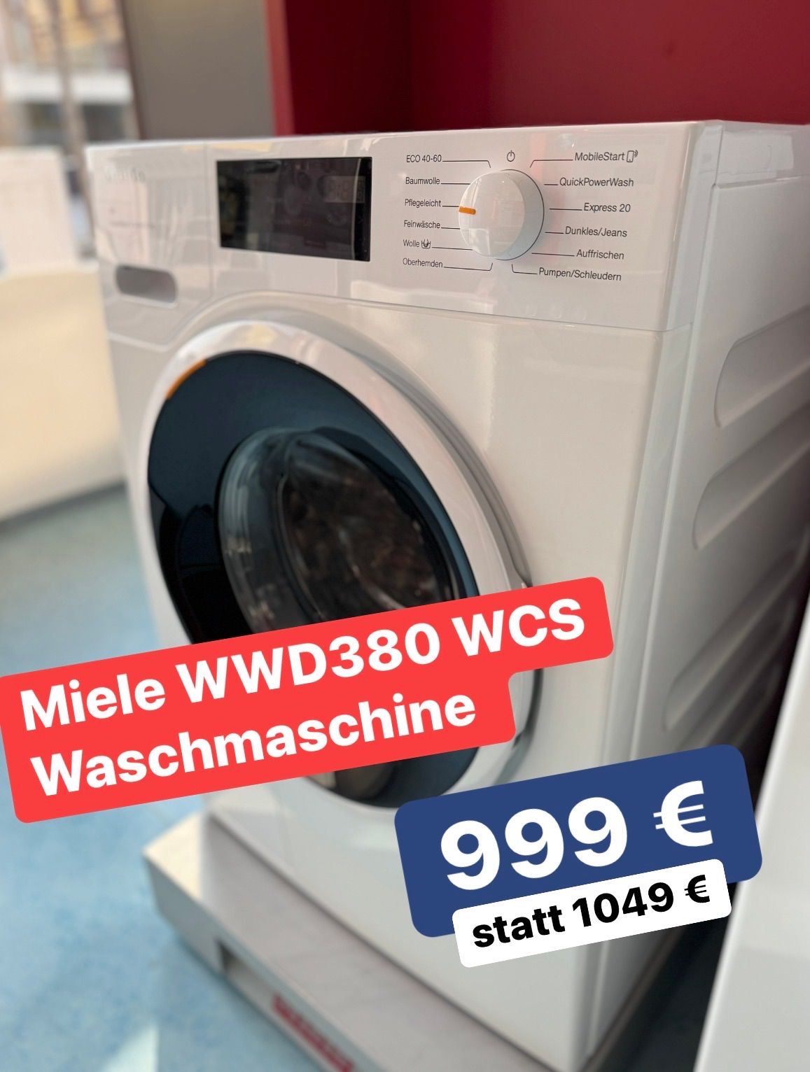 Eine weiße Frontlader-Waschmaschine von Miele, Modell WWD380 WCS, ist ausgestellt. Ein roter Aufkleber zeigt den Preis von '999 €' auf einem blauen Hintergrund mit weißer Schrift.