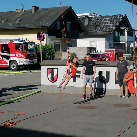 Bild enthält, Shoe, Person, Shorts, Neighborhood, Fire Truck, Truck, Vehicle, Handbag, Skipping Rope, Sword