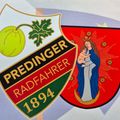 Zwei Abzeichen, eines mit einer Frucht und den Worten Preding Radfahrer 1894, und ein anderes mit einer Darstellung einer Frau, die ein Baby auf dem Mond hält.