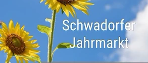 Zwei Sonnenblumen mit gelben Blütenblättern und grünen Blättern vor einem blauen Himmel mit Wolken. Die Worte 'Schwadorfer Jahrmarkt' sind in Weiß geschrieben.