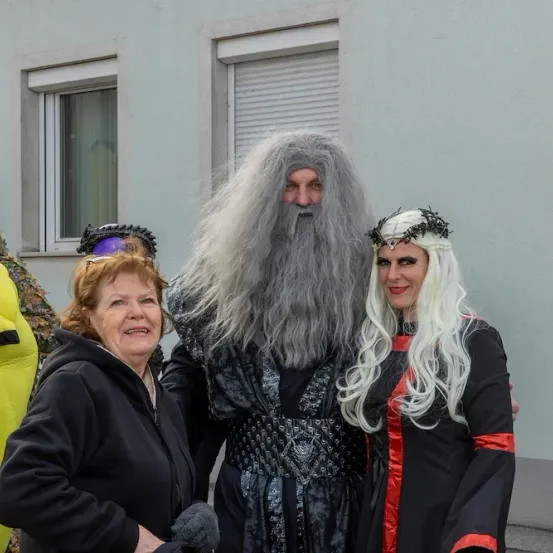 Eine Frau mit roten Haaren und eine Frau mit weißen Haaren posieren für ein Foto mit einem Mann, der als Gandalf verkleidet ist.