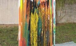 Ein großes abstraktes Gemälde steht im Freien. Es hat leuchtende, fließende Farben mit kräftigen Pinselstrichen. Das Gemälde ist an einer Betonwand montiert, vor dem sich eine Rasenfläche befindet.