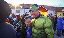 Ein Mann, der als Hulk verkleidet ist, und eine Frau stehen gemeinsam bei einer Zusammenkunft. Viele Menschen in Winterkleidung sind im Hintergrund zu sehen.