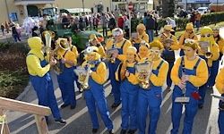 Eine Musikkapelle, verkleidet als Minions aus dem Film 'Ich - Einfach unverbesserlich', spielt Musikinstrumente bei einem Umzug.