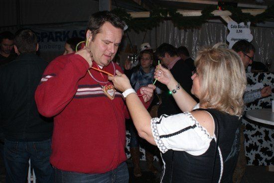 Ein Mann und eine Frau spielen mit einem Stock in einem überfüllten Raum mit Weihnachtsthema.