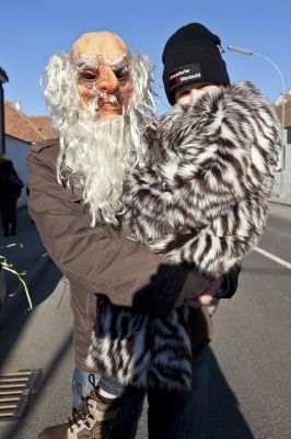 Ein Mann in einem Gandalf-Kostüm hält ein Kind in einem Leopardenfellmantel auf der Straße.