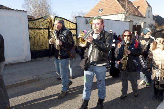 Eine Gruppe von Menschen in Punk-Kleidung spielt Blechblasinstrumente auf der Straße.