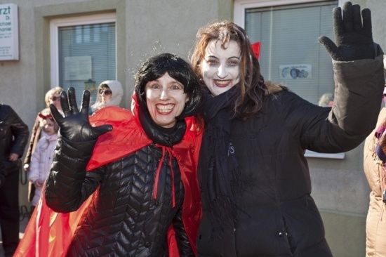 Zwei Frauen in Vampirkostümen posieren für ein Foto vor einem Gebäude.