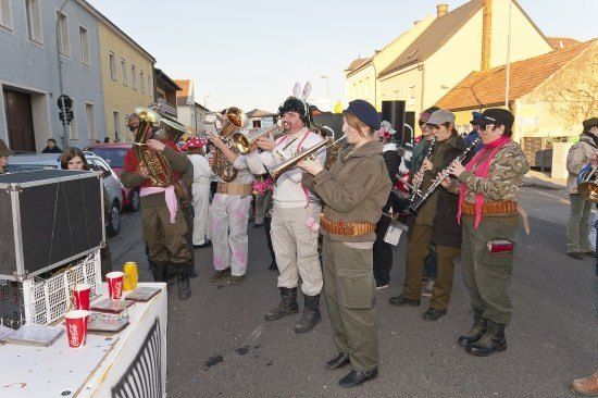 Eine Gruppe von Menschen in Militäruniformen spielt auf der Straße Musikinstrumente.