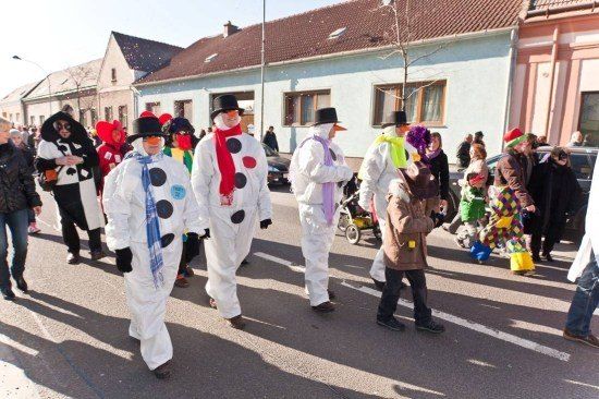 Eine Gruppe von Menschen in Schneemannkostümen zieht bei einer Parade auf einer Straße.