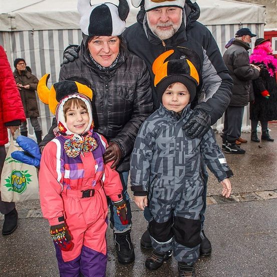 Eine Familie in Kuhkostümen, mit zwei Kindern und zwei Erwachsenen, steht im Freien.