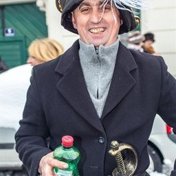 Ein Mann in einem Piratenkostüm hält eine Flasche Sprite und ein Schwert in den Händen. Er lächelt und steht draußen.