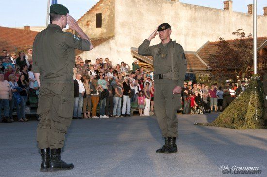 Zwei Militäroffiziere salutieren vor einer Menge während einer Zeremonie.