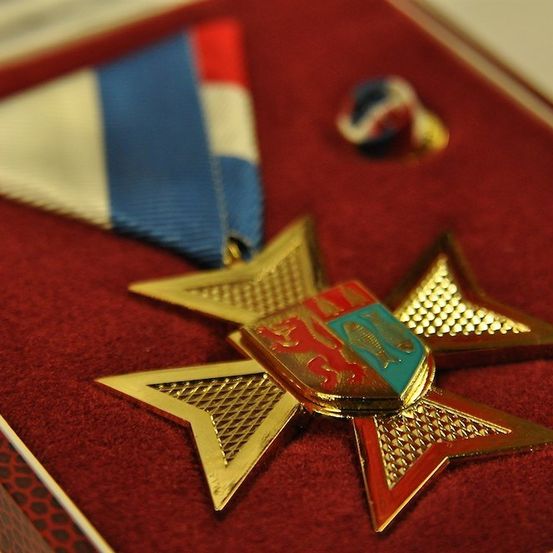 Eine goldene Sternmedaille mit einem rot-weiß-blauen Band ist in einer roten Samt-Schachtel ausgestellt.