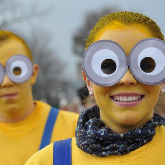 Zwei Personen, die als Minions aus dem Film 'Ich - Einfach unverbesserlich' verkleidet sind, einer mit gelber Gesichtsbemalung und der andere mit blauen Hosenträgern.