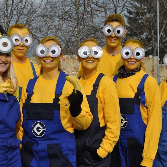 Eine Gruppe von Menschen, die als Minions aus dem Film Ich - Einfach unverbesserlich verkleidet sind, stehen zusammen, einer hält eine Banane.