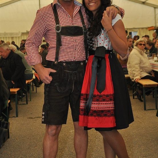 Ein Mann und eine Frau in traditioneller bayerischer Kleidung stehen bei einer Veranstaltung im Freien.
