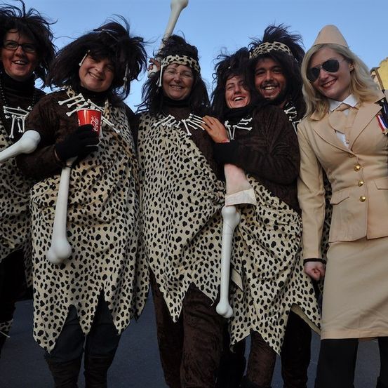 Eine Gruppe von Menschen in Leoparden-Kostümen, einer hält einen roten Becher, posiert für ein Foto.