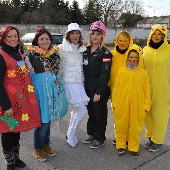 Eine Gruppe von Menschen in verschiedenen Kostümen, einschließlich Pikachu, steht auf einer Straße.