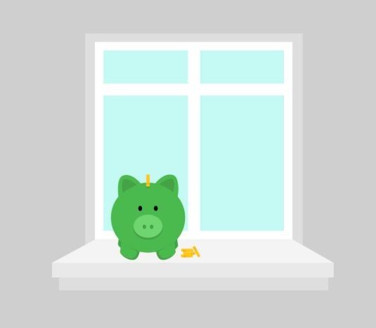 Eine grüne Sparschwein sitzt auf einer Fensterbank mit ein paar Münzen verstreut davor.