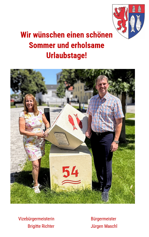 Ein Mann und eine Frau stehen neben einem Stein mit der Nummer 54. Die Frau hält den Stein, und der Mann steht neben ihr. Sie lächeln beide. Über ihnen ist ein Logo mit einem Löwen und einem Fisch. Unten stehen die Namen der Personen.