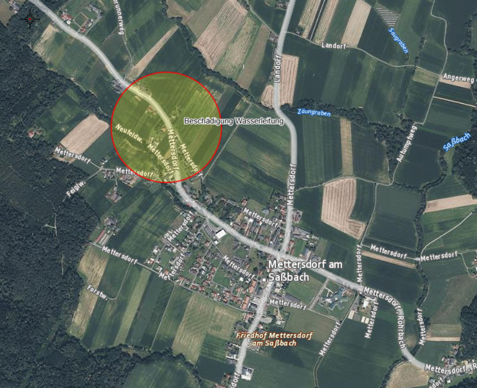 Luftaufnahme eines Dorfes namens Mettersdorf. Ein Wasserleitungsschaden ist mit einem roten Kreis markiert. Das Gebiet ist von Feldern und Straßen umgeben.