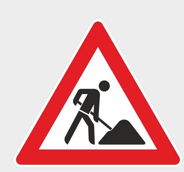 A road sign showing a person shoveling dirt with a warning triangle background.