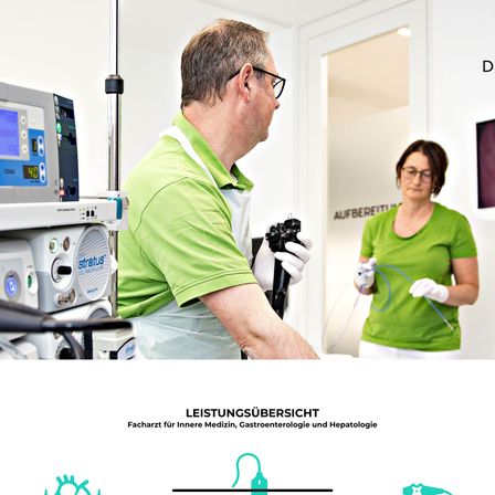 Zwei medizinische Fachkräfte in grünen Scrubs führen einen Eingriff durch. Der Mann hält ein medizinisches Gerät, und die Frau hat einen Schlauch in der Hand. Medizinische Geräte sind im Hintergrund.