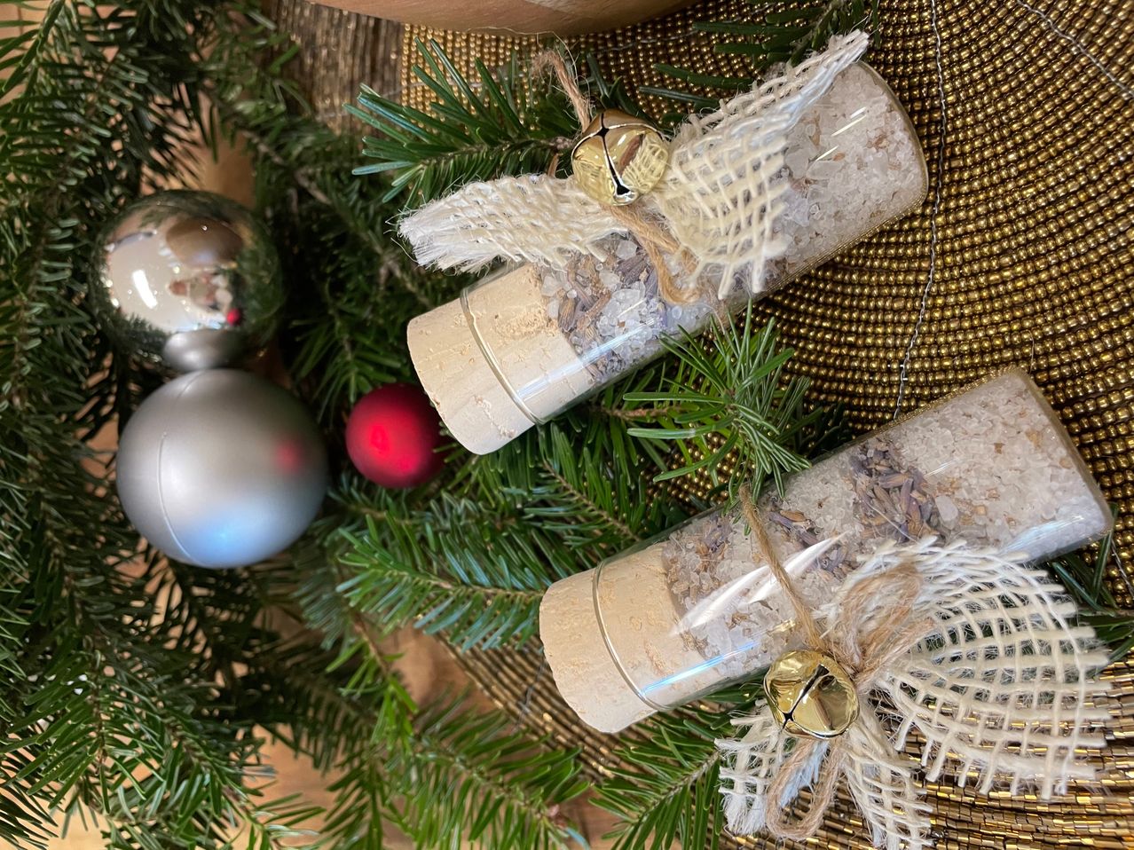 Zwei kleine Röhrchen mit einer Mischung aus Kräutern und Gewürzen sind in Jute gewickelt und auf einem Weihnachtskranz platziert. Eine rote Kugel und eine silberne Kugel befinden sich ebenfalls auf dem Kranz.