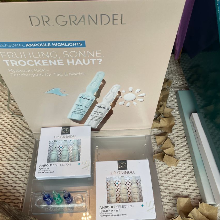 Eine Box mit Hautpflegeprodukten von Dr. Grandel wird gezeigt. Die Box enthält saisonale Ampullen-Highlights für die Hydratation. Verschiedene Ampullen sind in der Box zu sehen, zusammen mit anderen Hautpflegeprodukten.