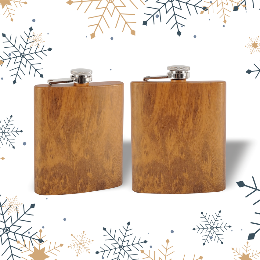 Zwei hölzerne Hüftflaschen mit silbernen Verschlüssen auf weißem Hintergrund mit Schneeflocken.