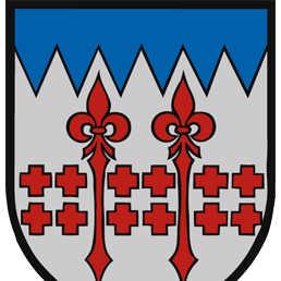 Ein Schild mit einem blauen oberen Rand zeigt einen weißen Hintergrund mit zwei roten Fleur-de-Lis in der Mitte und einem roten Kreuzmuster darunter.