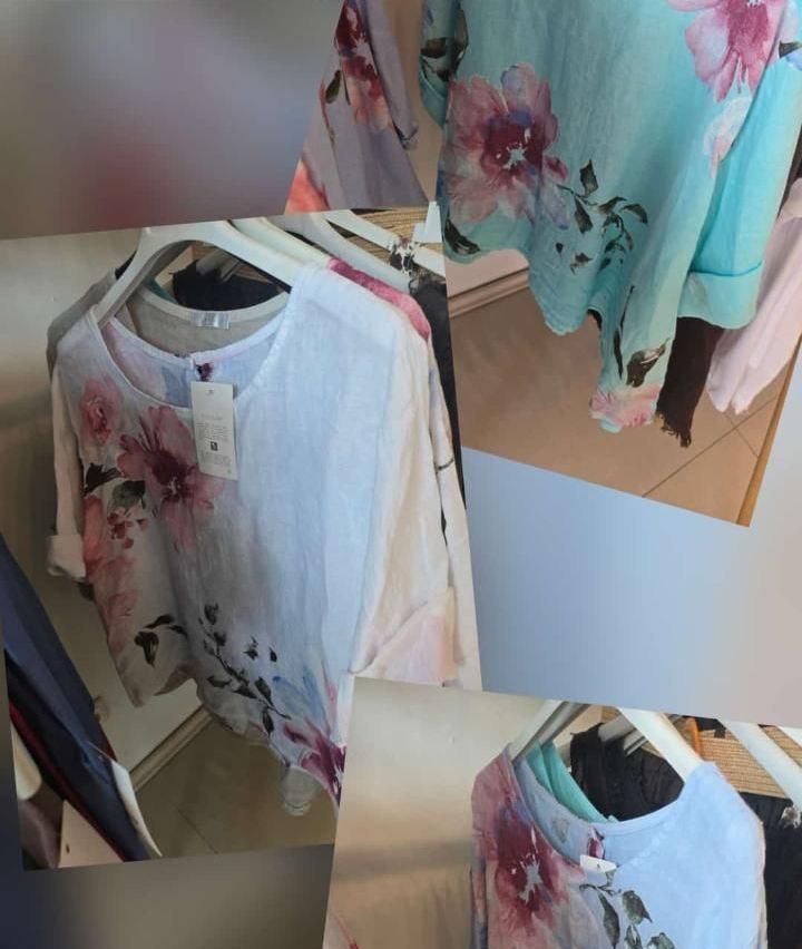 Mehrere blusen mit blumenmuster sind in einem geschäft ausgestellt. Einige hemden hängen an kleiderbügeln, während andere gefaltet sind. Ein preisschild ist an einem der hemden sichtbar.