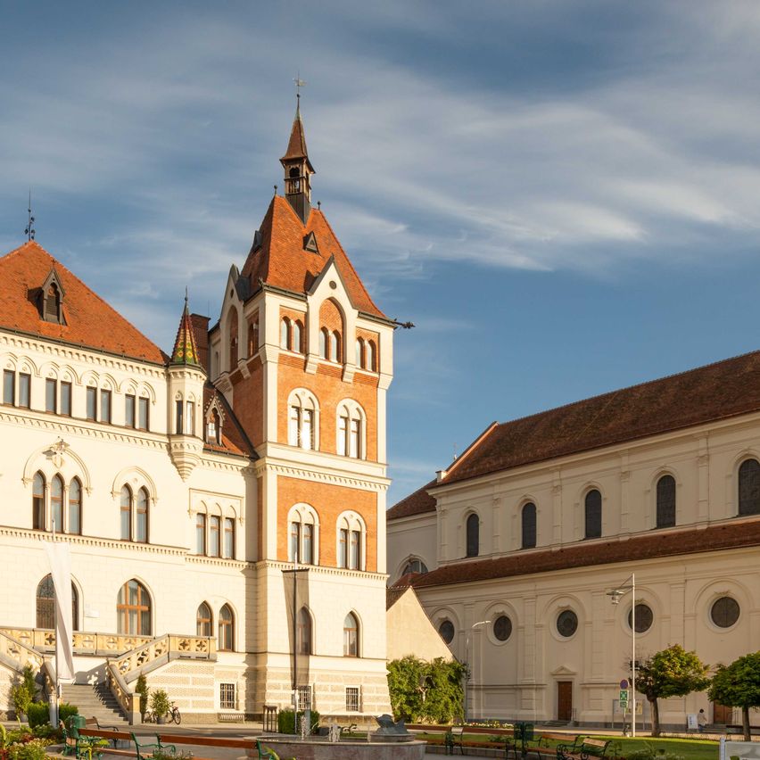 Bild enthält, Building, Spire, Grass, Campus, Clock Tower, City, Person, Gothic Arch, Bench, Cathedral