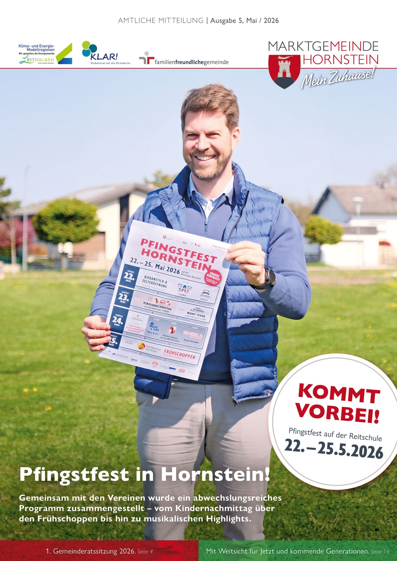 Ein Mann in einer blauen Weste hält ein Plakat, das das Pfingstfest in Hornstein vom 22. bis 25. Mai 2026 auf einem Rasenfeld bewirbt.