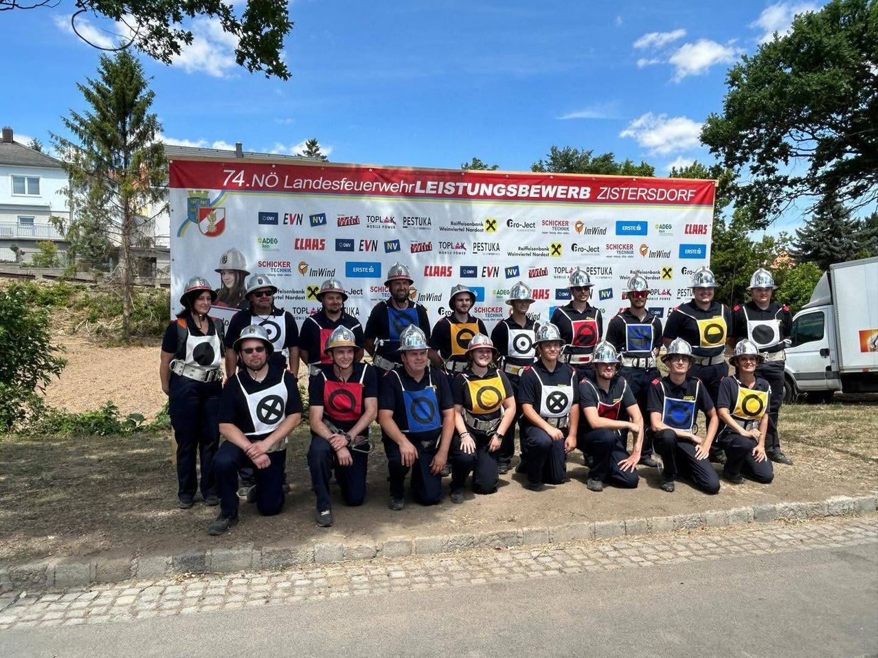 Eine Gruppe Feuerwehrleute in Uniform posiert für ein Foto beim 74. Landesfeuerwehrleistungsbewerb in Zistersdorf.