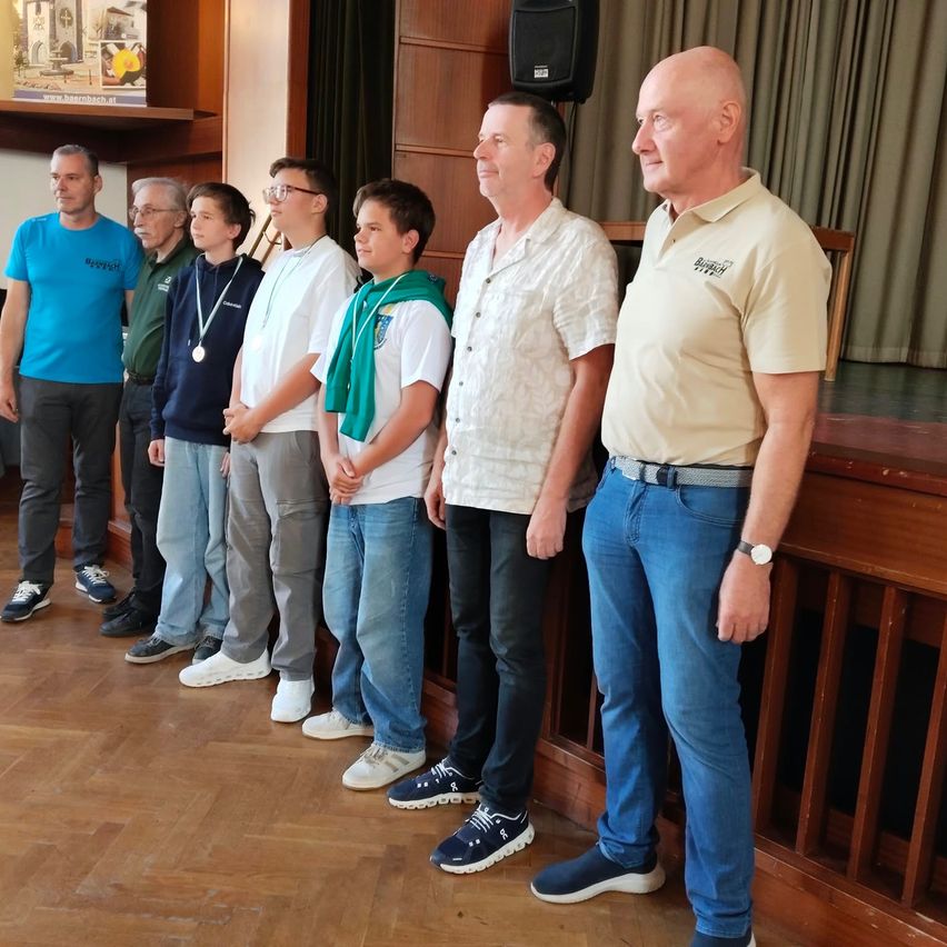 Eine Gruppe von Menschen, einschließlich Erwachsener und Kinder, stehen zusammen in einem Raum. Sie tragen alle Freizeitkleidung und scheinen für ein Foto zu posieren.