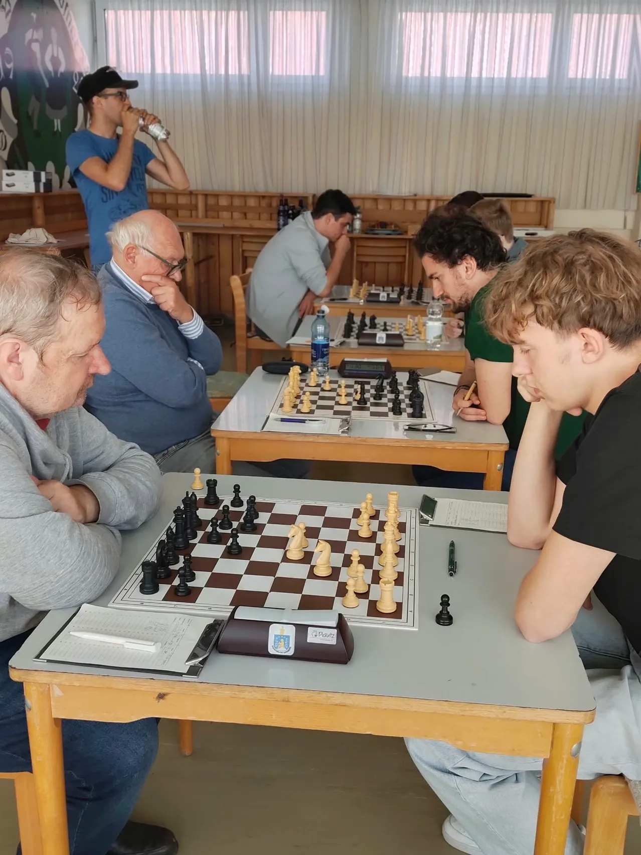 Eine Gruppe von Menschen spielt Schach in einem Raum.