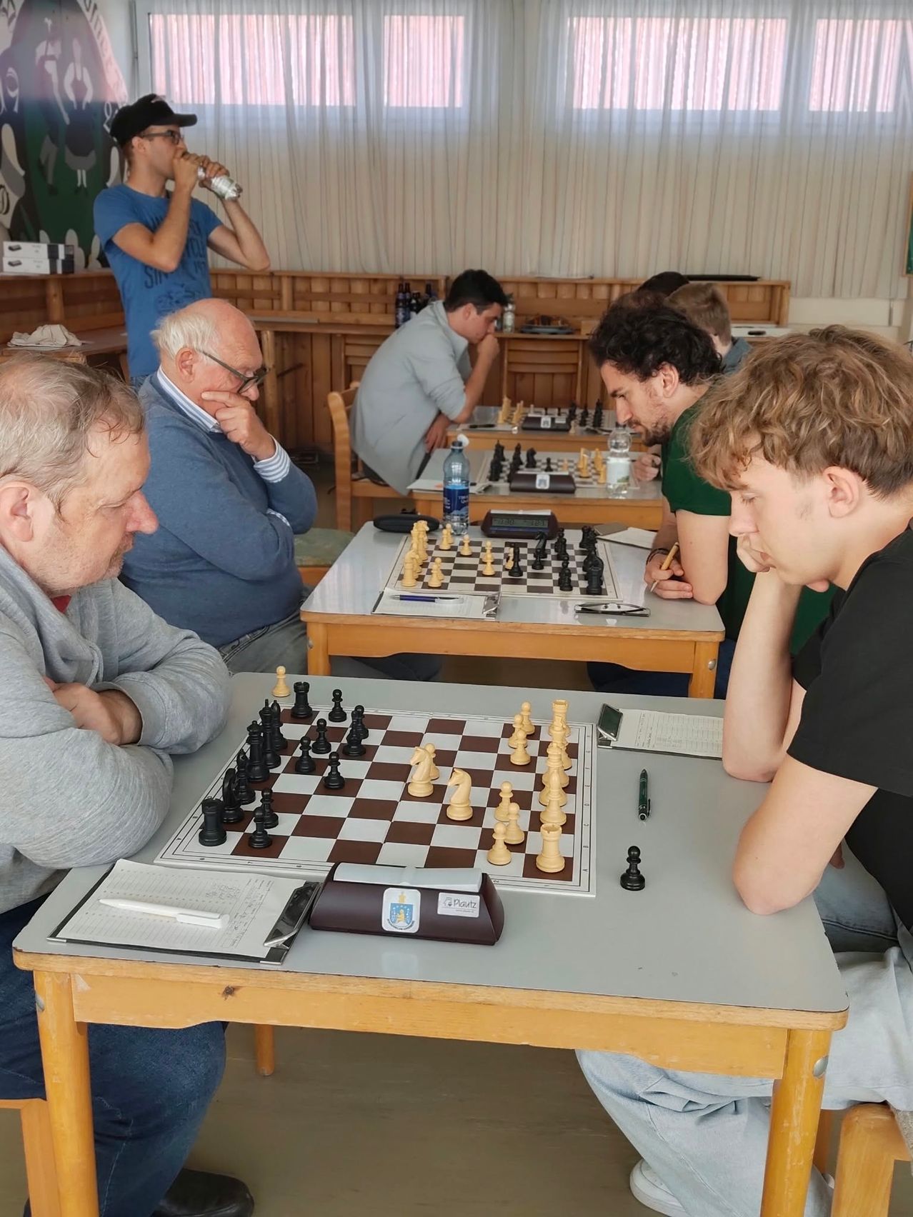 Eine Gruppe von Menschen spielt Schach in einem Raum.