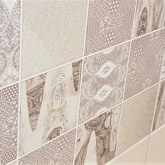 Eine Nahaufnahme einer gefliesten Wand mit verschiedenen komplizierten Mustern und Designs, hauptsächlich in Beige- und Brauntönen.