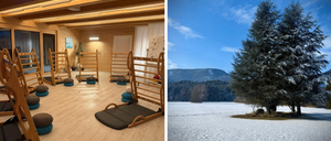 Das Bild zeigt das Innere eines Fitnessstudios mit Holzgeräten und einer verschneiten Außenlandschaft mit einem Baum.