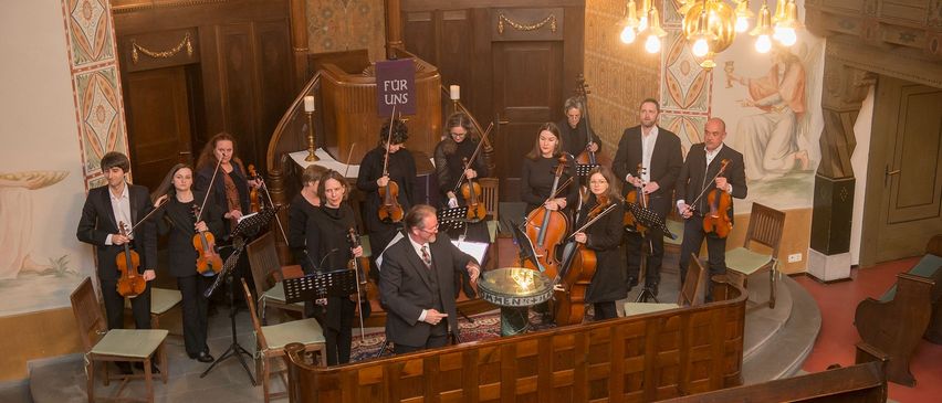 Bild enthält, Indoors, Person, Chandelier, Adult, Male, Man, Music, Musician, Performer, Orchestra